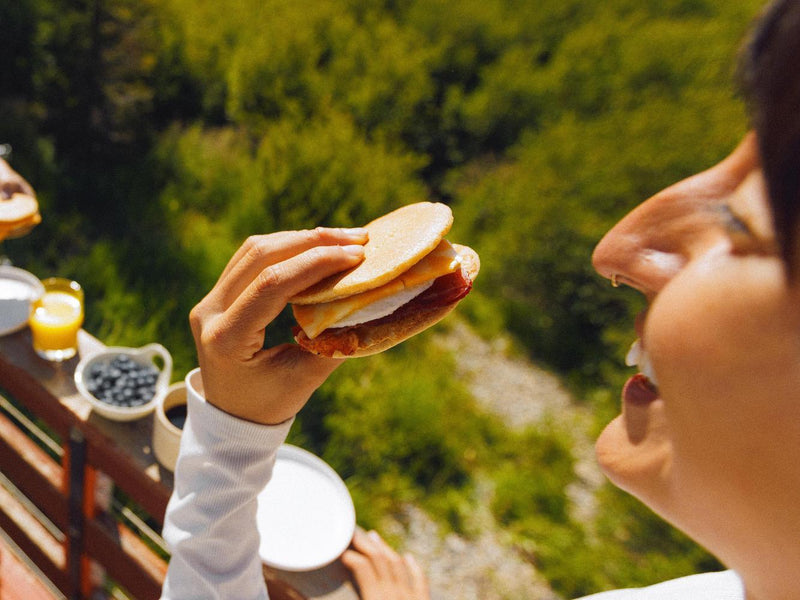 woman enjoying a frozen breakfast sandwich